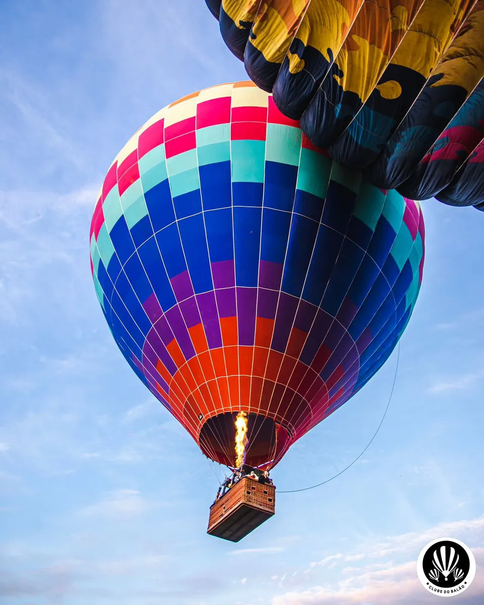 Balão colorido decolando com chama acesa ao entardecer
